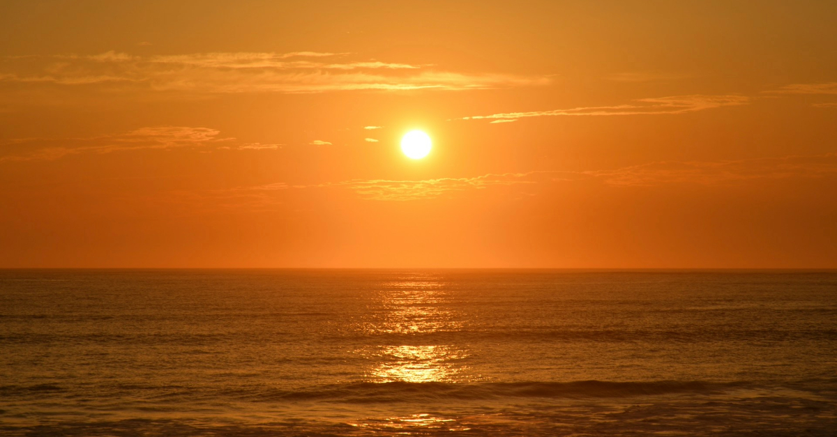 Golden sunrise reflected over a calm ocean, representing the start of a creative writing journey