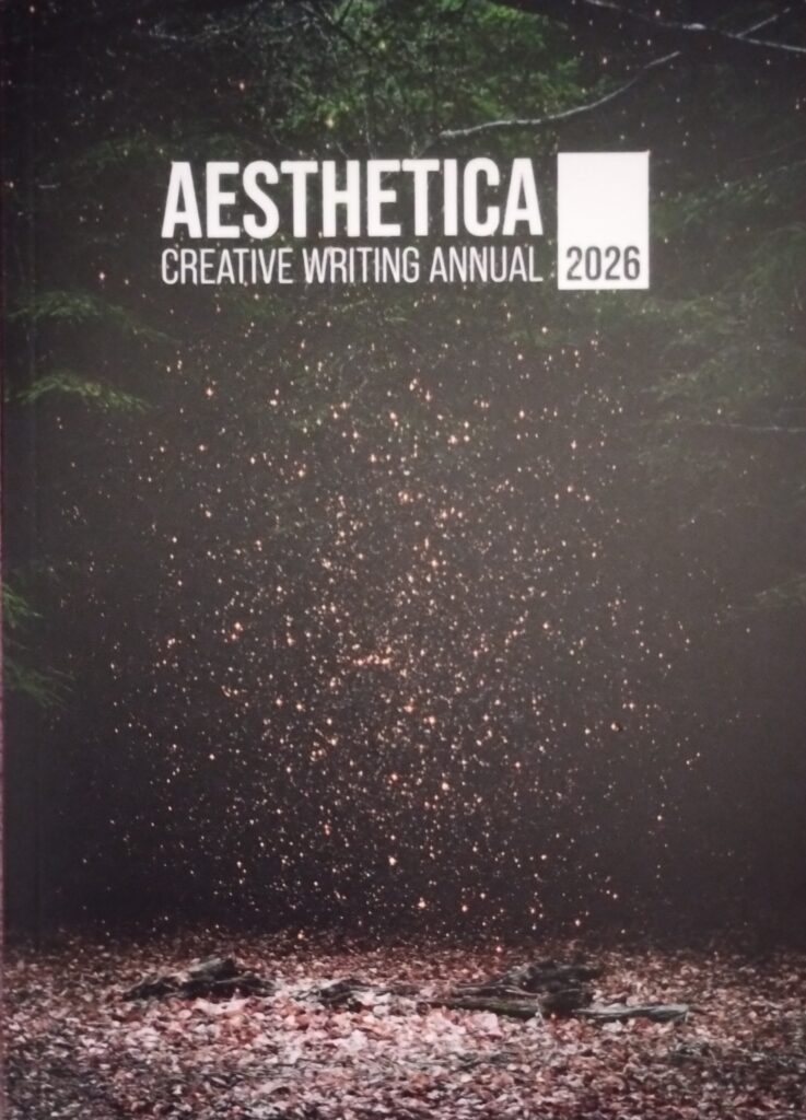 AestheticA Creative Writing Annual 2026 text over a background of a forest floor and glowing particles